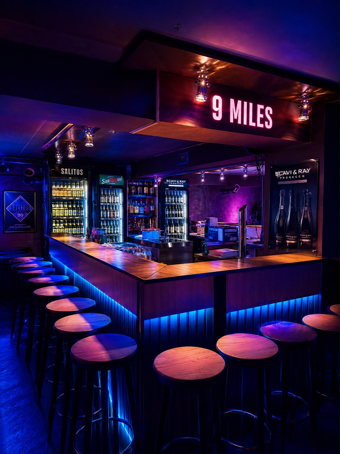 Professionelle Bar mit blauer LED-Beleuchtung und Holztheke im Club Schacht 4